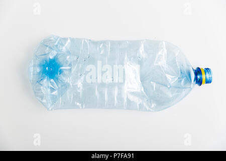 Crushed blue plastic bottle on white background. pollution concept Stock Photo