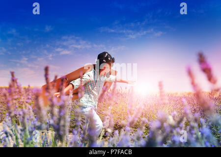 Boy pilot running through the lavender meadow Stock Photo