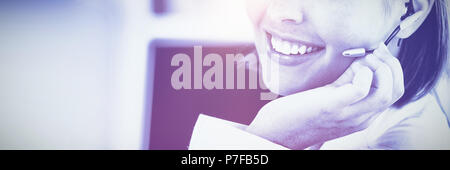 Cute businesswoman talking with clients in front of her computer Stock Photo