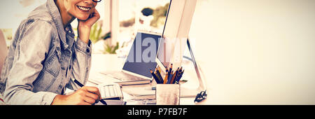 Blonde pretty designer looking at the camera using digitizer Stock Photo
