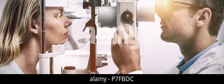 Optometrist examining female patient on slit lamp Stock Photo