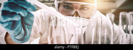 Close up of a protected science student dropping liquid in a test tube Stock Photo