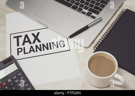 Tax Planning written on white paper with laptop computer and coffee cup. Business and finance concept. Stock Photo