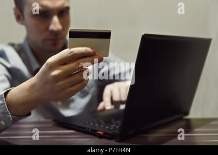 Businessman hand holding credit card and use laptop Stock Photo