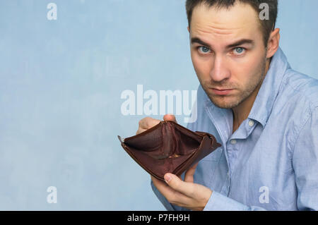 Bankruptcy - Business Person holding an empty wallet. Man showing empty wallet by showing the inconsistency and lack of money and not able to pay the  Stock Photo