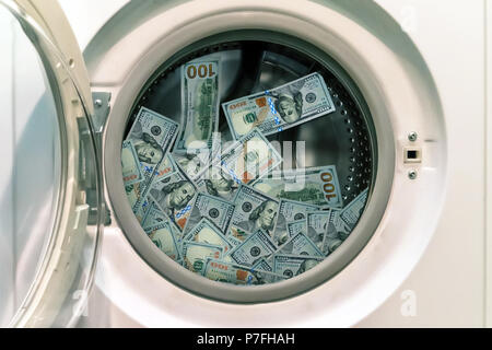 Close-up Of Pile Of Dirty Money Placed In Washing Machine. concept of laundering illegal money. launder money. black market Stock Photo