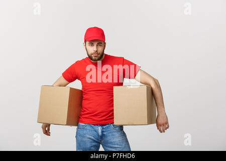 Exhausted handsome delivery man holding boxes and taking a break. Isolated on white Stock Photo