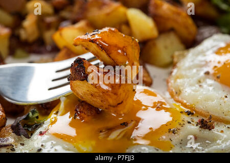 Eating Eggs and Fries with small pieces of fat pork meat, onion and garlic - close up view Stock Photo