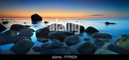 Sunset at the Baltic Sea, boulders on the shore, behind the Schwanenstein, Lohme, Jasmund National Park, Island of Rügen Stock Photo