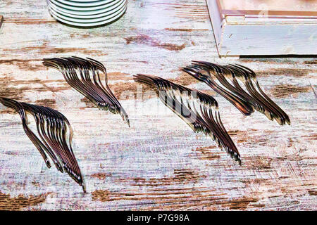 Many forks placed on a wooden table - selective focus Stock Photo