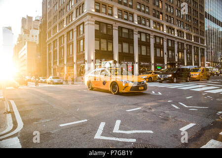 NEW YORK CITY - JUNE 16, 2018: View of midtown Manhattan at intersection with cars, taxi cabs and people on a typical day. Stock Photo