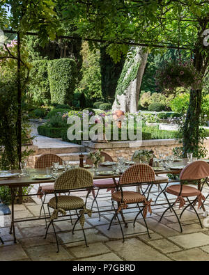 Table and chairs under pergola on terrace of 18th century chateaux, St Remy de Provence Stock Photo