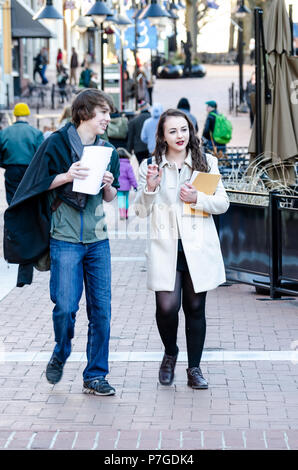 Charlottesville, USA - January 10, 2015: Two students couple walking in downtown Main Street mall in Virginia college town, city closeup happy talking Stock Photo