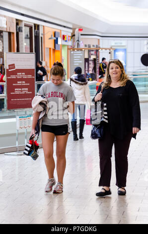 Fairfax, USA - January 2, 2015: Mother and daughter walking together in Fair Oaks shopping mall holding, carrying bags after Sephora retail store, sho Stock Photo