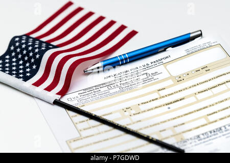 Fairfax, USA - April 11, 2018: U.S. Department of State application for US, American passport on table with pen, flag Stock Photo