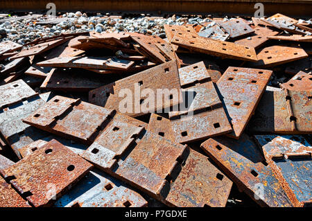 Pile of scrap rail railway railroad track rusty grungy metal plates covered in rust, abandoned in junk yard with grunge Stock Photo