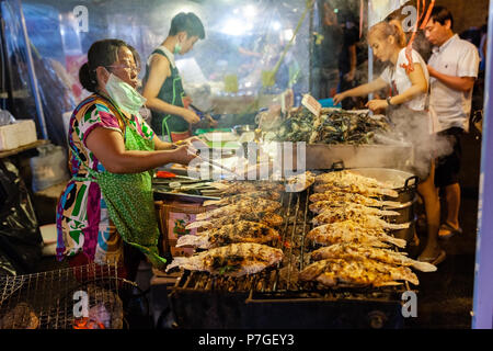 CHIANG MAI, THAILAND - AUGUST 27: Food vendor cooks fish at the Saturday Night Market (Walking Street) on August 27, 2016 in Chiang Mai, Thailand. Stock Photo