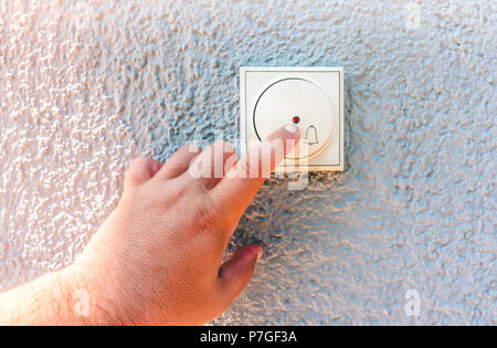 hand ringing on doorbell on pvc front door Stock Photo