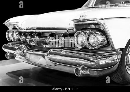 Chrysler Imperial Crown 1959 in black and white. Selective focus on the right headlights. Isolated on black background Stock Photo