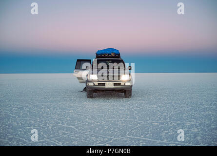 Land Cruiser during twilight in Uyuni salt flats (Salar de Uyuni) Bolivia, South America. Jun 2018 Stock Photo