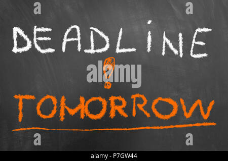 Deadline tomorrow chalk text on blackboard or chalkboard as time pressure stress work exam due concept Stock Photo