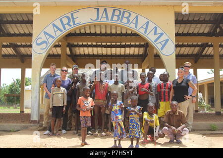 Soldiers and airmen of Task Force Darby pose for a photo with children of Saare Jabbaama June 28, 2018 near Contingency Location, Garoua in Cameroon during a visit. TF Darby service members are serving in a support role for the Cameroonian Military’s fight against the violent extremist organization Boko Haram. Stock Photo