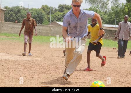 1st Lt. Pierce Willenbrock of the Task Force Darby, 1st Battalion, 32nd Infantry Regiment, 10th Mountain Division security force, plays soccer with children from the Saare Jabbaama children’s home June 28, 2018 near Contingency Location Garoua in Cameroon. TF Darby service members are serving in a support role for the Cameroonian Military’s fight against the violent extremist organization Boko Haram. Stock Photo
