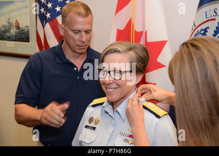Rear Adm. Joanna Nunan, the Ninth District Commander, has her shoulder boards replaced by her husband and daughter during a promotion ceremony July 3, 2018 in Cleveland. Nunan was advanced from Rear Adm. Lower Half to Rear Adm. Upper Half. (U.S. Coast Guard photo by Petty Officer 2nd Class Christopher M. Yaw) Stock Photo