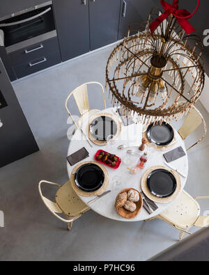 View from mezzanine down on laid table with vintage metal Tolix dining chairs Stock Photo