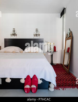 Pair of red morccan slippers in elegant sleeping area of modern open plan apartment Stock Photo