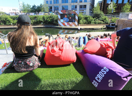 People relaxing on the steps at Granary Square, Kings Cross, to watch the Everyman Summer of Love Film Festival, in north London, UK Stock Photo