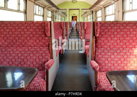 Passenger Carriage with people being seated and chatting. July 03 2018 - Carrog, Wales, UK. - Rail Station. Stock Photo