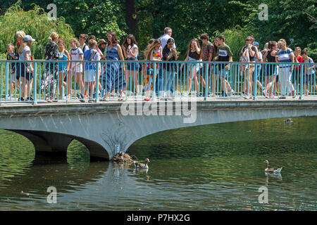 People enjoys the sunshine in Green Park, central London, as the warm weather continues across the country. Stock Photo