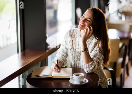 Portrait of happy young woman in cafe Stock Photo