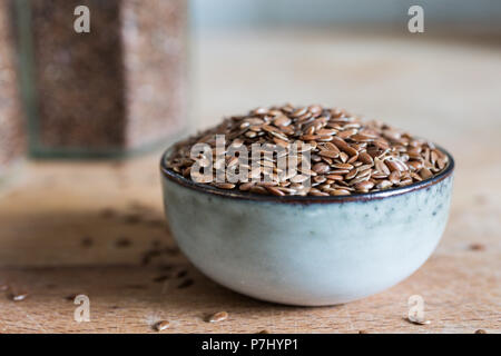 bowl on wooden table with superfood healthy linseed flaxseed grain cereal Stock Photo