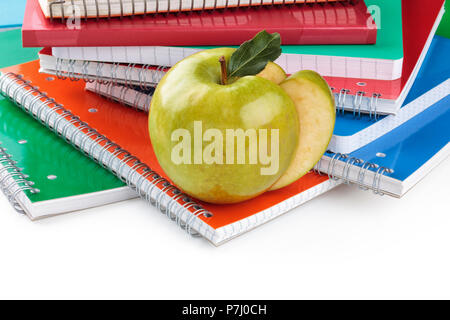 Border of notebooks  and green apple. Isolated on white background. Stock Photo