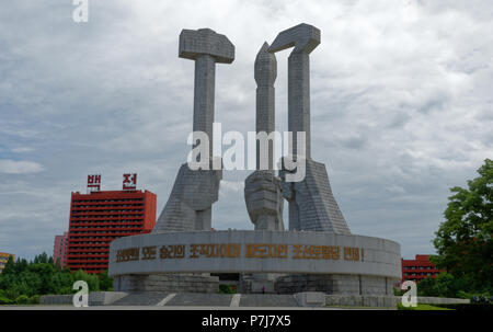 The Workers Party  Monument aka The Monument To Party Founding with Hammer, Sickle and  brush with murals in Pyongyang Stock Photo