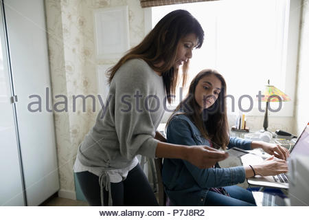 Mother and daughter online shopping at laptop in home office
