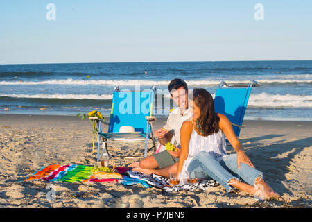Couple sitting on beach having a picnic, Sea Girt, New Jersey, United States Stock Photo