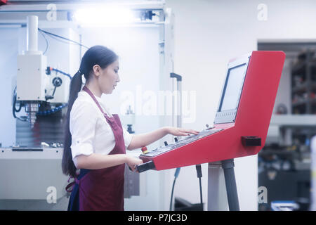 Female engineer operating machinery in a workshop Stock Photo