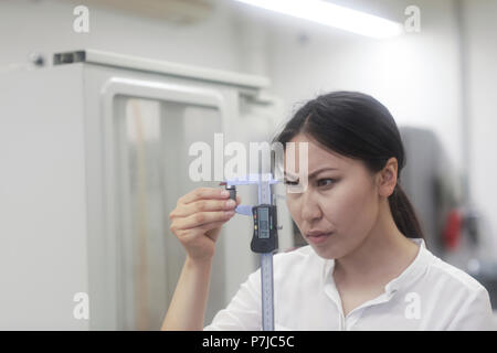 Female engineer using a measuring stick Stock Photo