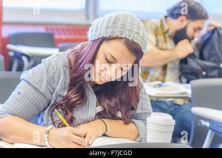 Two people at college sitting at desks working Stock Photo