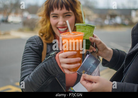 Two women making a celebratory toast with juice drinks Stock Photo