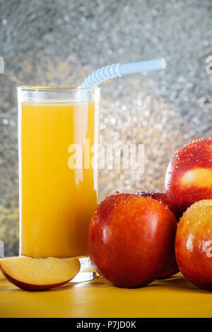 Bottle of orange juice next to a stack of apples Stock Photo