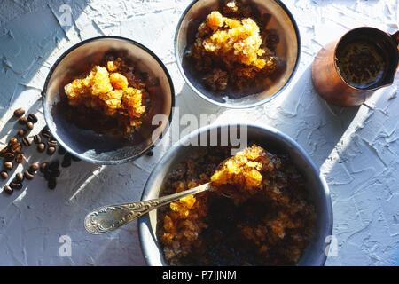 Dish for dessert with coffee ice, a bowl and grains on the table top view. Sicilian granite horizontal Stock Photo