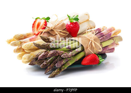 White and green asparagus with strawberries in front of white background Stock Photo