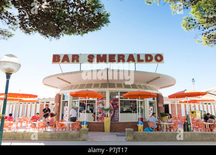 View of 'Smeralda' beach bar and guests sitting in front of it, architecture on the beach of Lignano Stock Photo