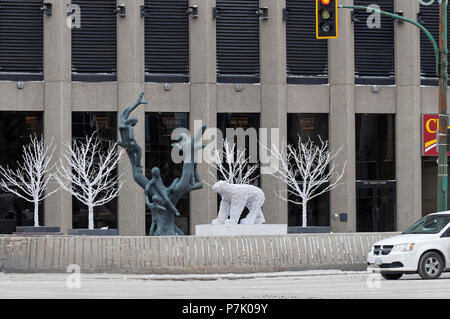 WINNIPEG, CANADA - 2014-11-17: Tree Children sculpture by Leo Mol surrounded by winter decorations in front of the Richardson Building on Portage ave in the centre of Manitoba capital Winnipeg city Stock Photo