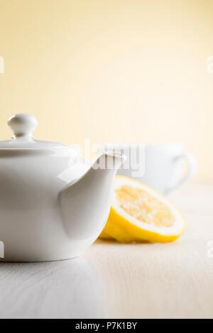 white teapot on table with lemon slices Stock Photo