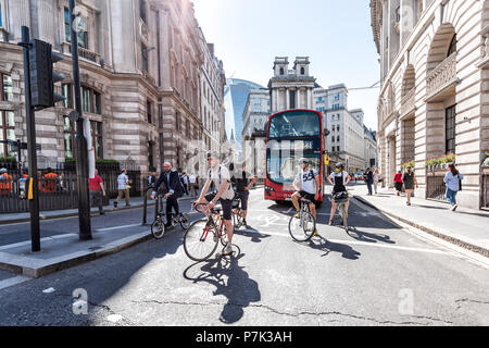 London, UK - June 26, 2018: Many people men pedestrians on bicycles riding waiting for traffic light on bikes street road in center of downtown financ Stock Photo